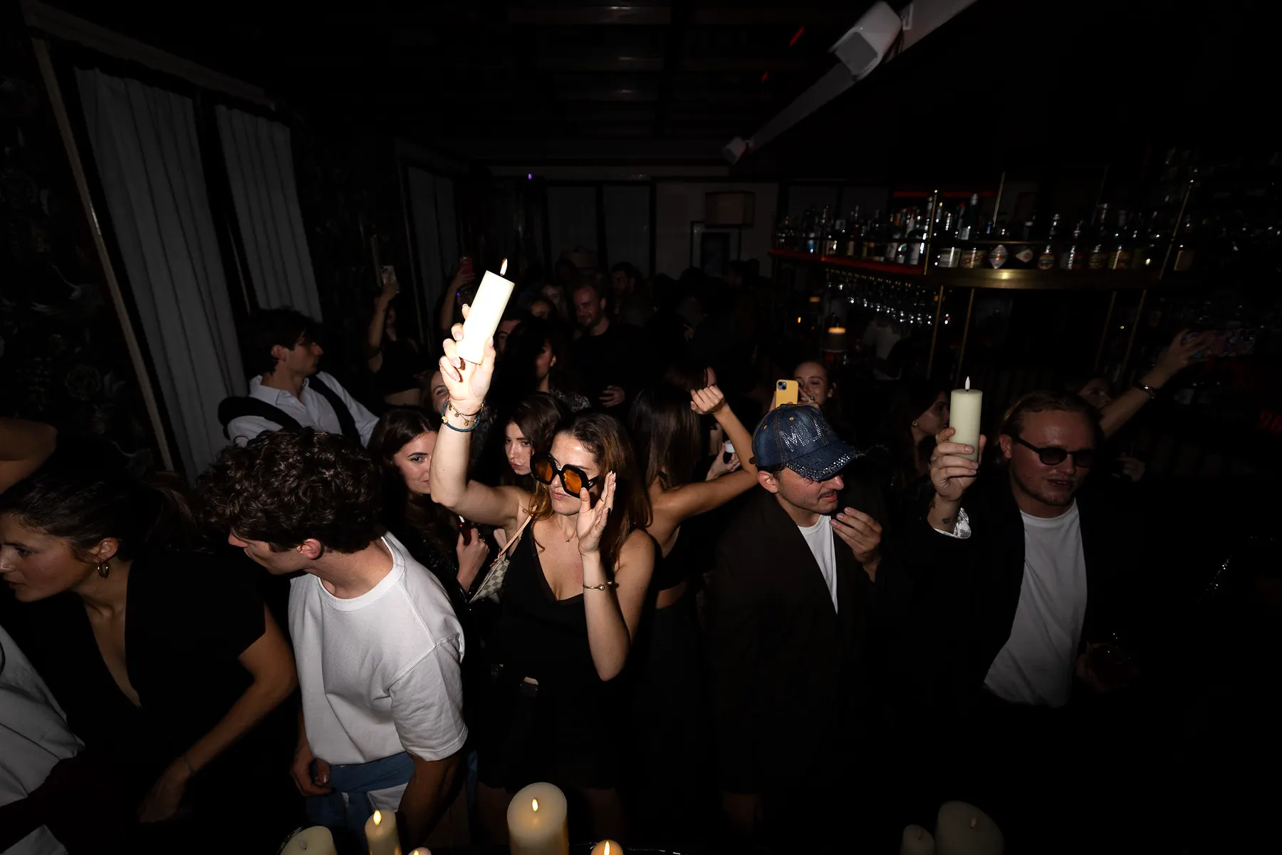 Gäste feiern mit Kerzen in der Hand bei einem Abend des Dionysos Social Club